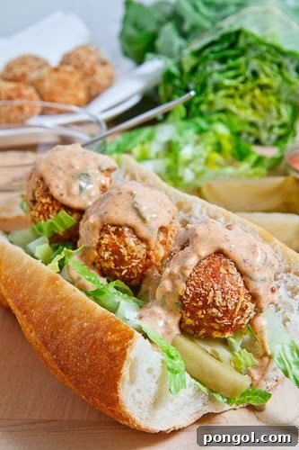 A savory Fried Tuna Ball Po Boy sandwich, overflowing with crispy tuna balls and fresh toppings.