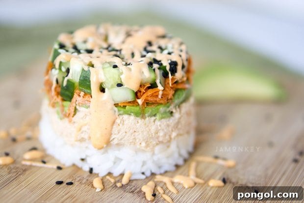 A beautifully presented Spicy Tuna Sushi Stack, layered with rice, tuna, avocado, and tobiko.