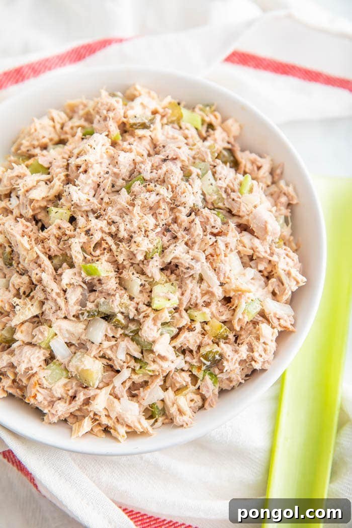 A scoop of classic Easy Tuna Salad served in a bowl, garnished with fresh parsley.