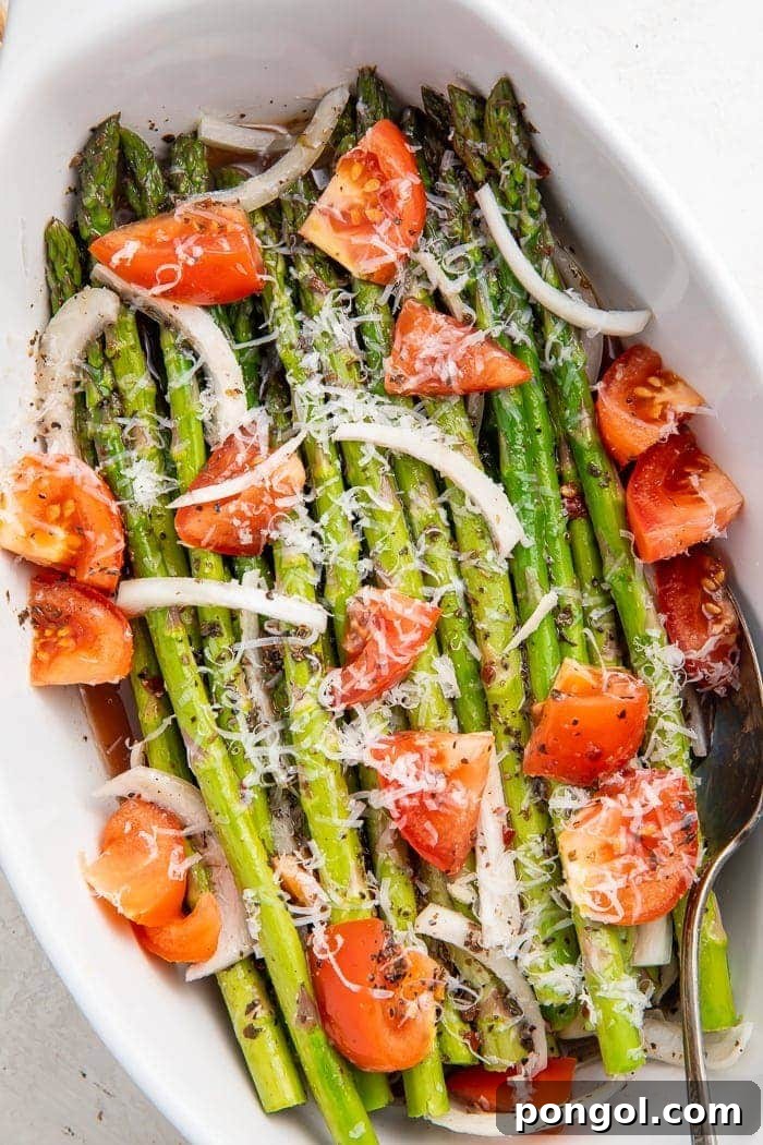 A vibrant cold asparagus salad in a white bowl, garnished with fresh herbs and Parmesan, ready to be served as a refreshing summer side dish.