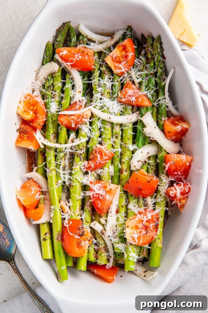 Close-up of cold asparagus salad in a serving dish, with a serving spoon nestled in the fresh vegetables, ready for guests.