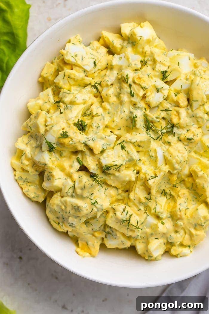 Close-up of creamy keto egg salad in a bowl, garnished with fresh dill.