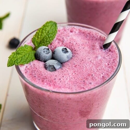 A vibrant blueberry smoothie in a glass, ready to be enjoyed.