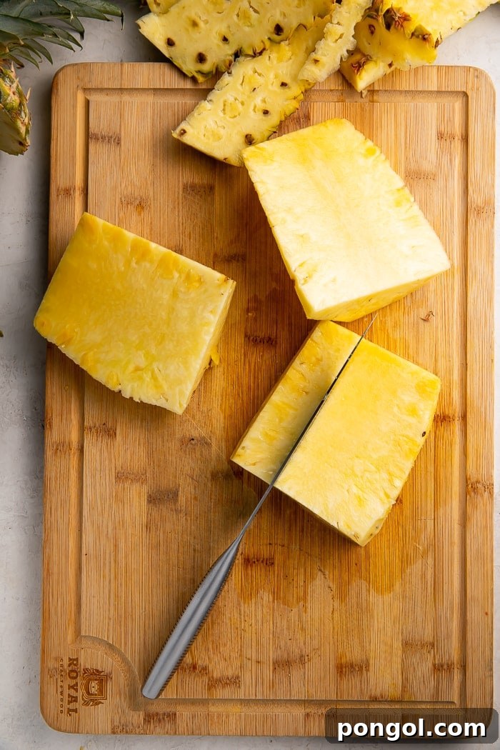 Unlock the Secret to Easy Pineapple Slicing 6 A slab of pineapple lying flat on a cutting board, ready for slicing