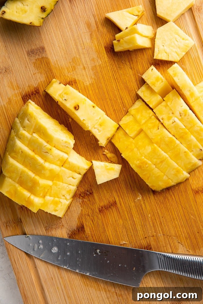 Unlock the Secret to Easy Pineapple Slicing 8 Pineapple strips being cut into uniform cubes