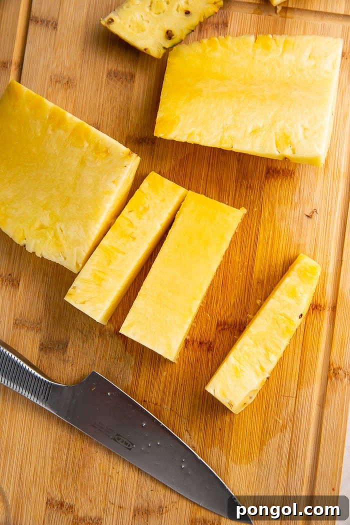 Unlock the Secret to Easy Pineapple Slicing 9 Thin slices of pineapple being cut away from the central core
