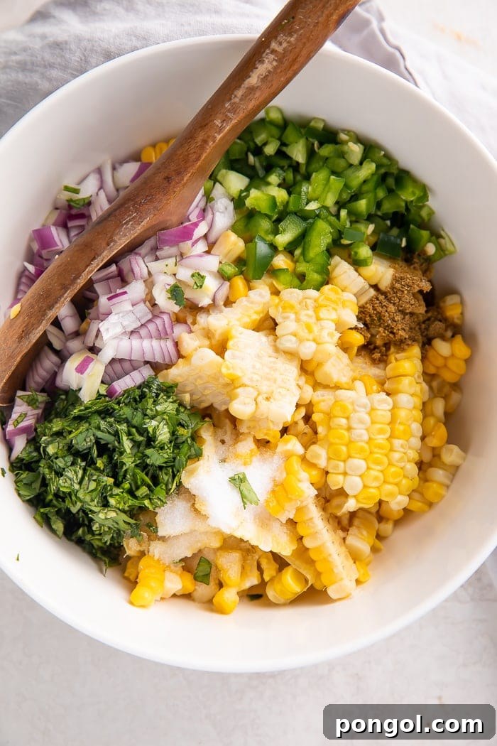 Preparing the ingredients for corn salsa: chopped red onion, cilantro, and corn in bowls.