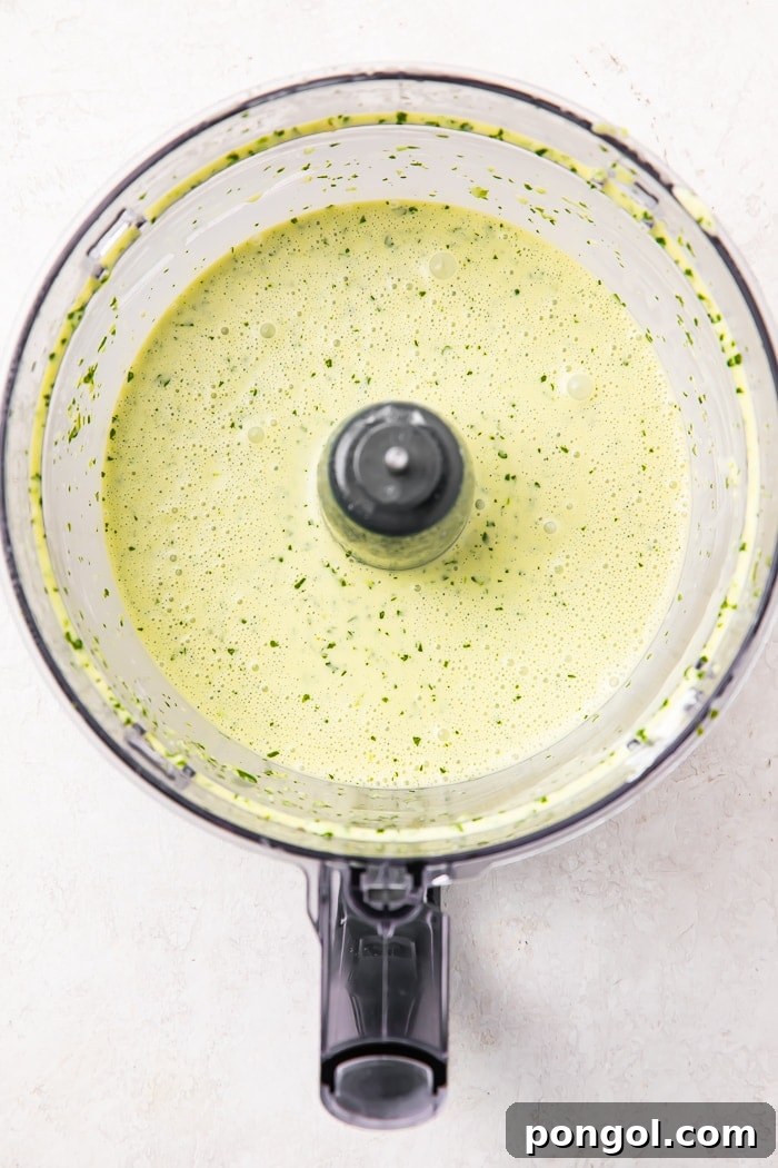 Two small glass jars of cilantro lime dressing, one with a spoon, ready to be served or stored.