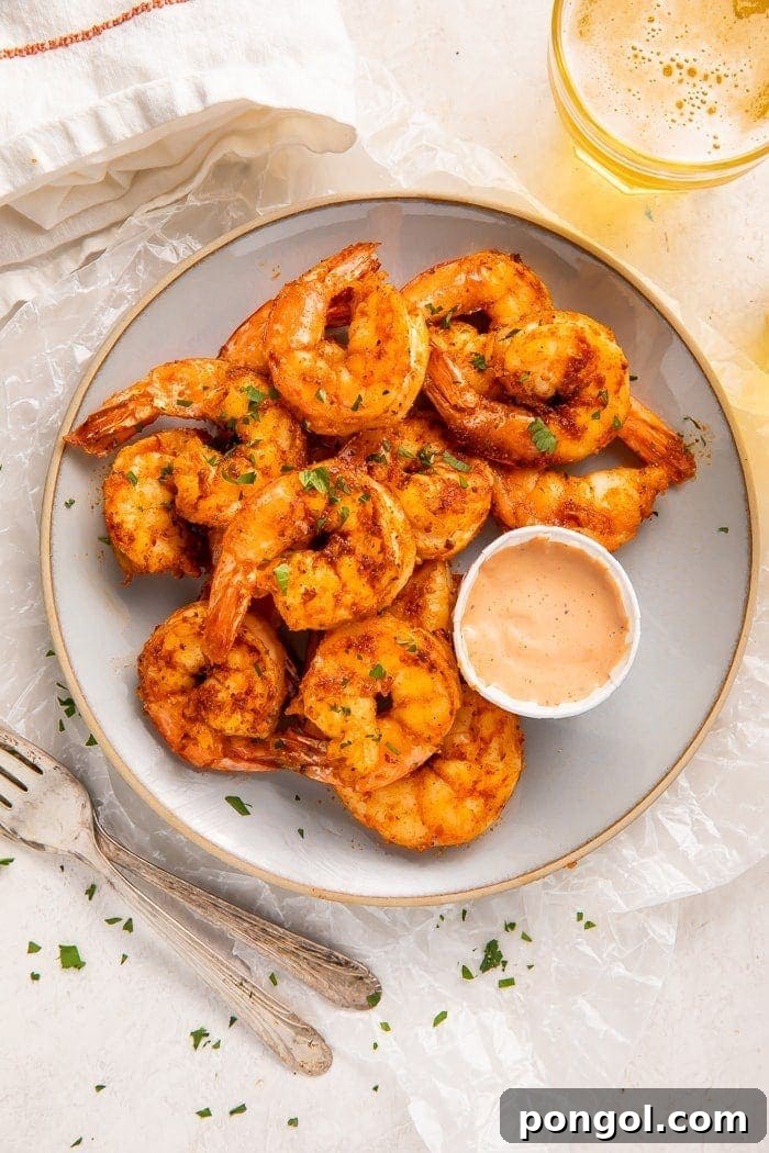 Plate of air fryer shrimp with comeback sauce in a cup