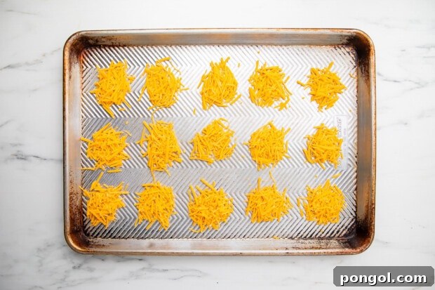 Cheesy Keto Crisps 8 Shredded cheddar cheese piles on baking sheet