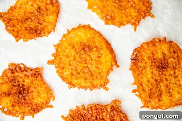 Cheesy Keto Crisps 9 Baked keto cheese chips on parchment paper