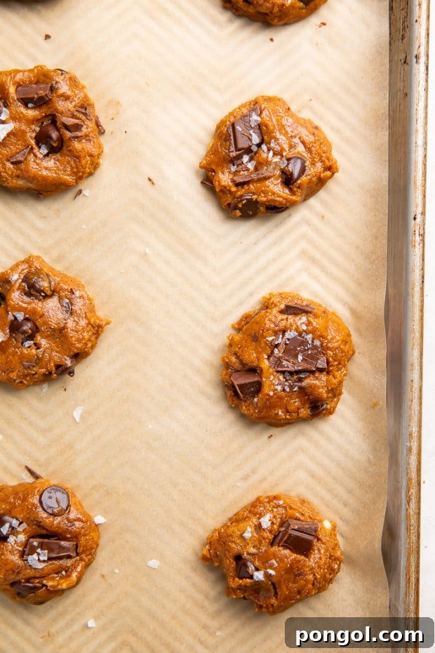 Scooping and flattening paleo cookie dough on parchment paper