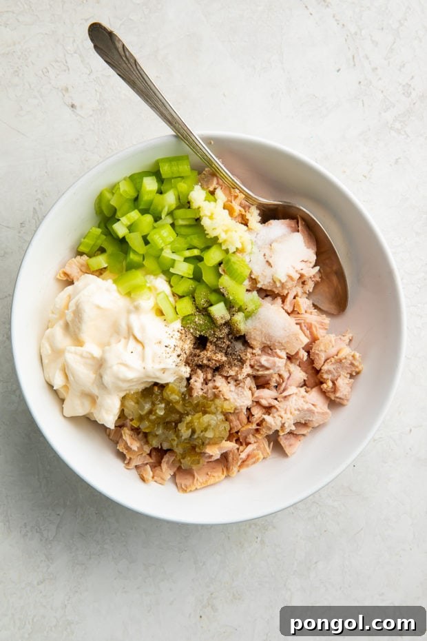 Keto tuna salad ingredients being mixed in a bowl.