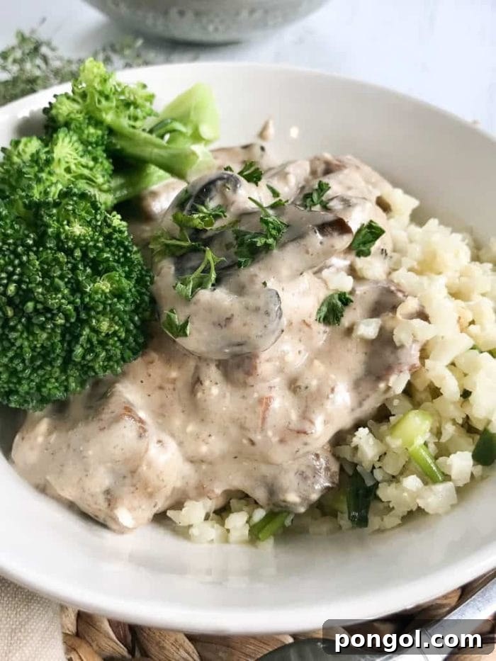 Creamy Slow Cooker Garlic Chicken Alfredo with tender chicken and bright green broccoli florets.