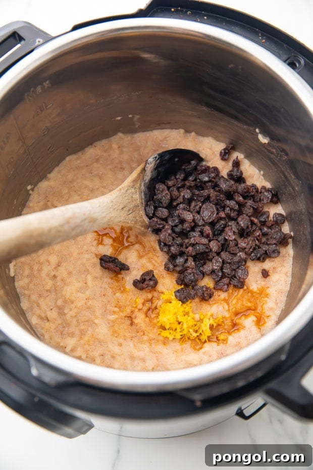 Adding butter, raisins, cinnamon, vanilla extract, and lemon zest to the freshly cooked rice pudding in the Instant Pot
