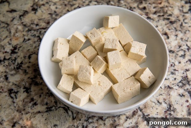 Tofu being pressed and cut into cubes