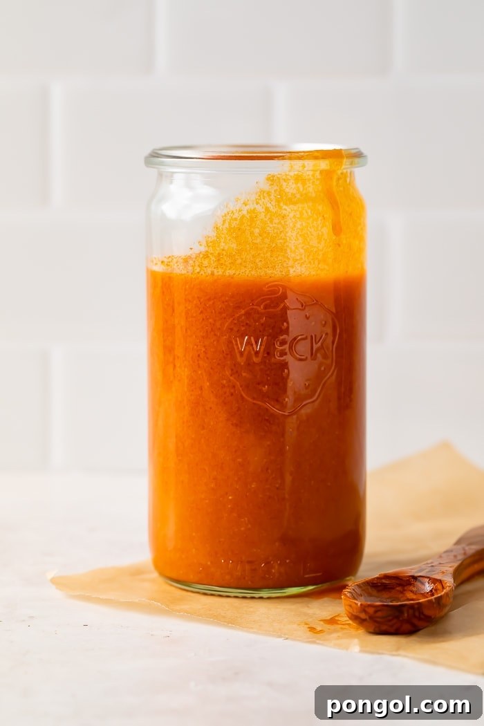Close-up of buffalo sauce simmering in a pot.