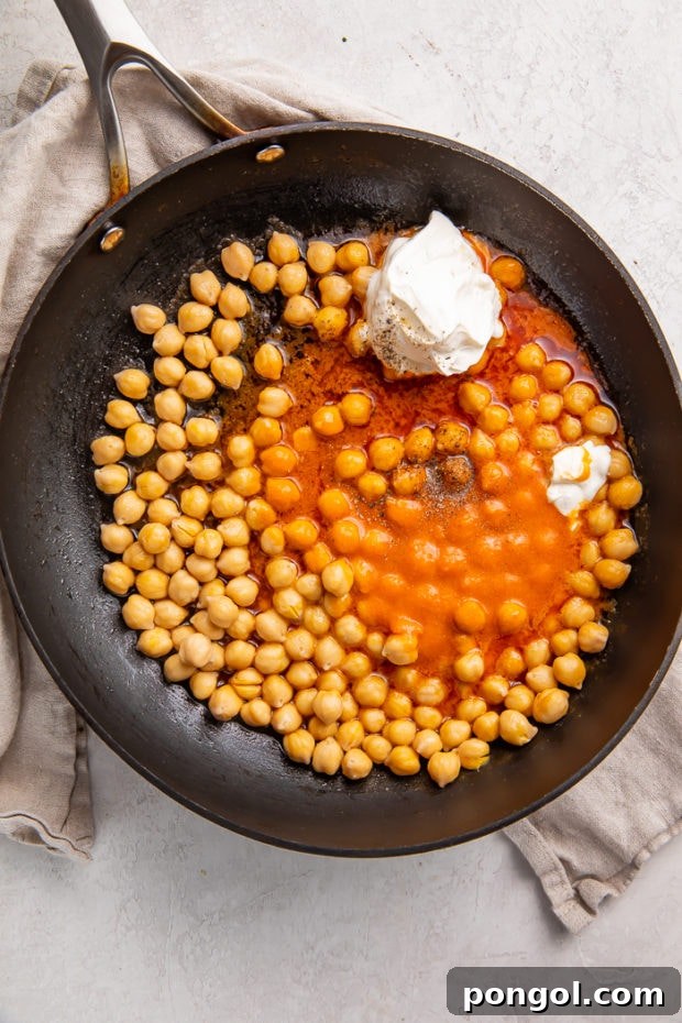 Fired Up Buffalo Chickpea Bowl 7 Chickpeas browning in a skillet with oil before adding buffalo sauce.