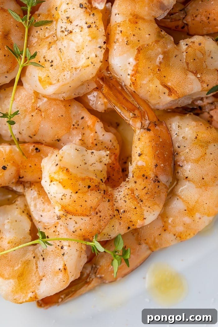 Close-up of cooked shrimp seasoned with pepper and garnished with parsley