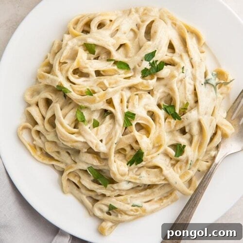 White plate of pasta with vegan alfredo sauce
