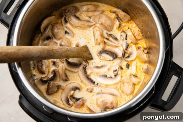 Instant Pot tom kha soup in Instant Pot with wooden spoon