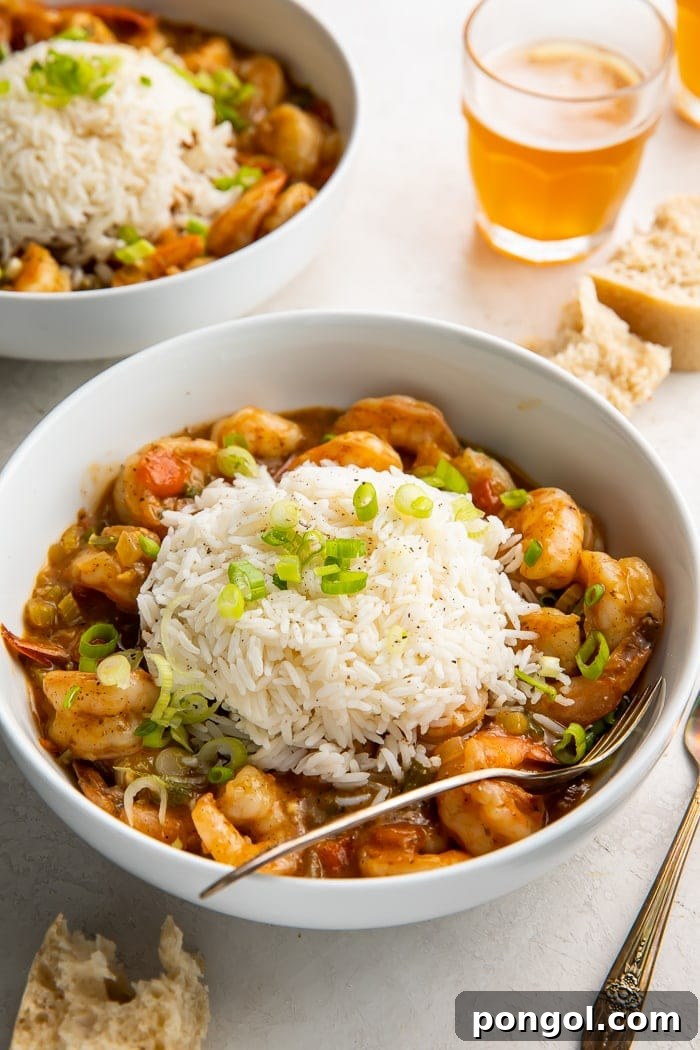 Cajun Shrimp Delight 2 A bowl of shrimp etouffee with a spoon in it, showcasing its rich texture and vibrant color.