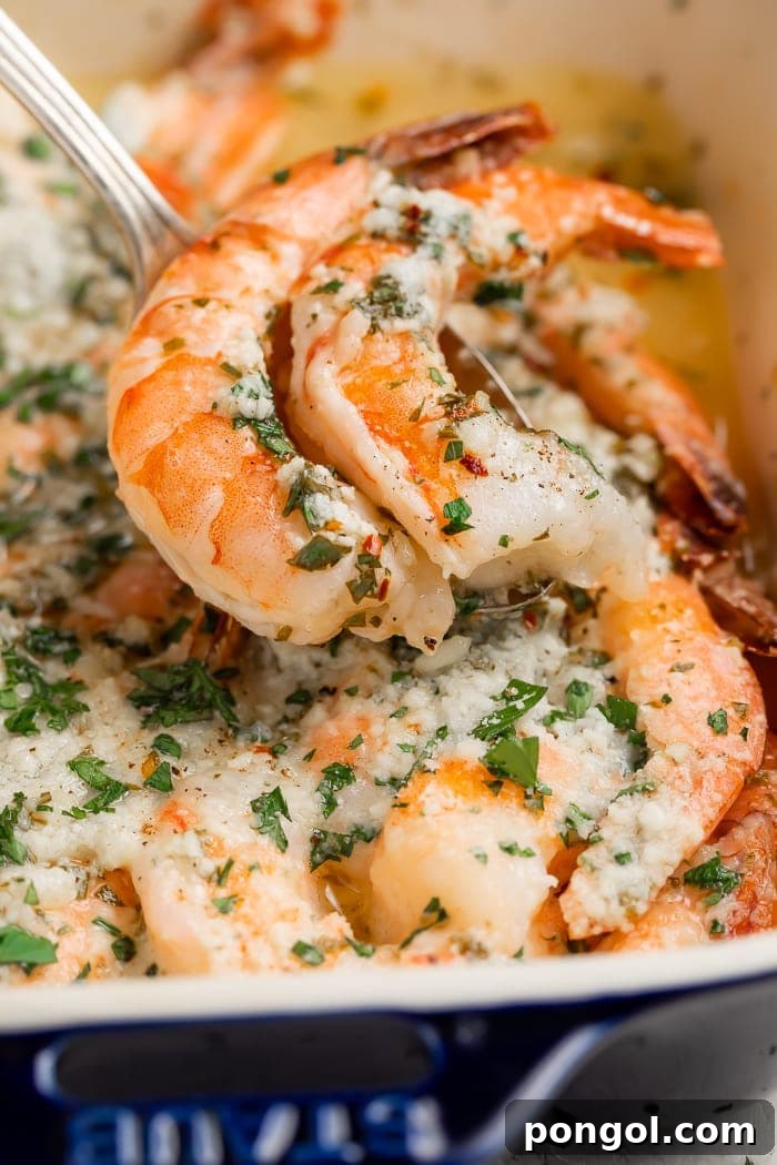 Golden Oven-Kissed Shrimp 7 Baked shrimp being served from a baking dish with a spoon.