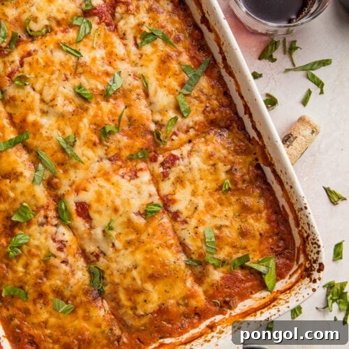 Overhead view of a casserole dish full of eggplant lasagna. cut into 12 large squares.