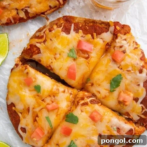 Overhead shot of Taco Bell Mexican pizza recipe topped with diced tomatoes and cilantro, surrounded by a glass of beer and lime wedges