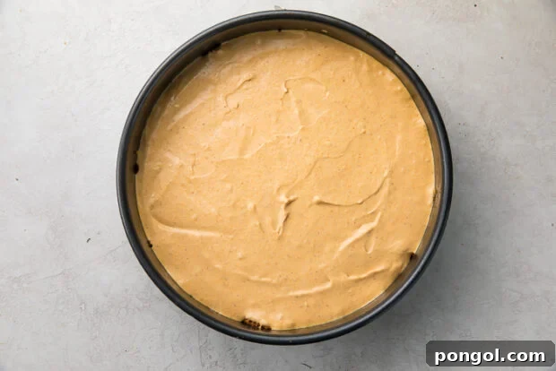 Spreading pumpkin cheesecake batter into the crust