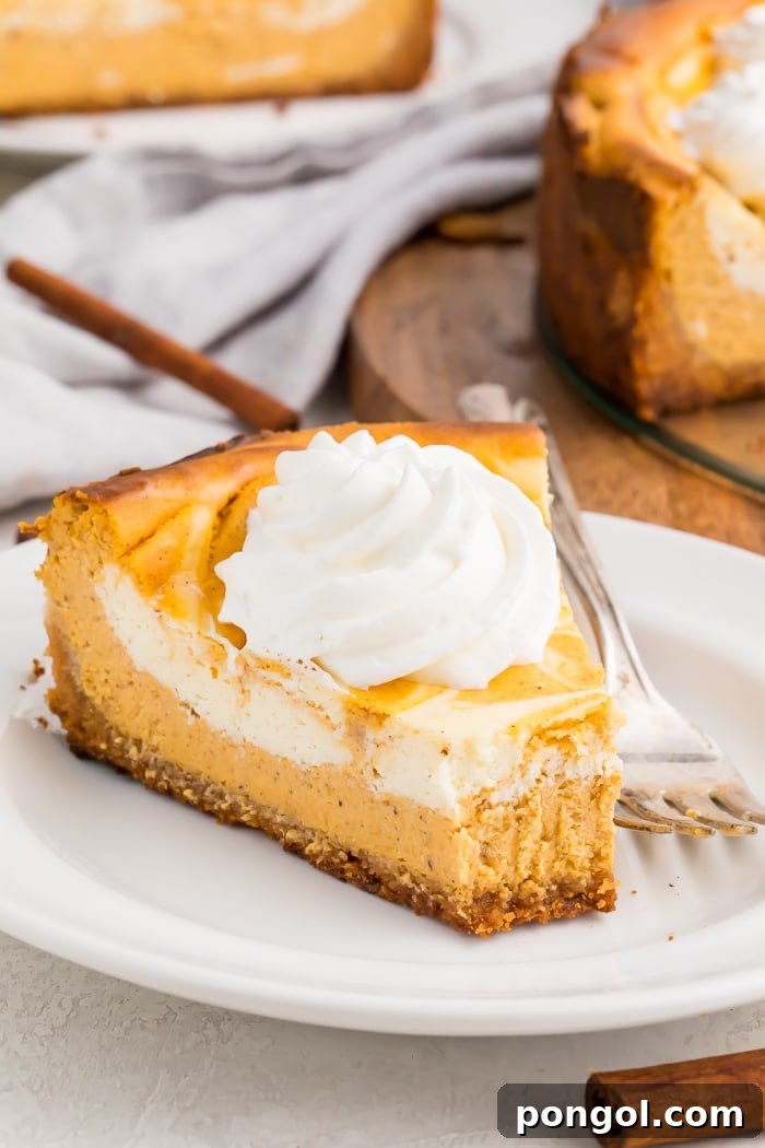Decadent Keto Pumpkin Cheesecake 4 A slice of keto pumpkin cheesecake with a dollop of whipped cream with a bite taken out on a white plate with a fork