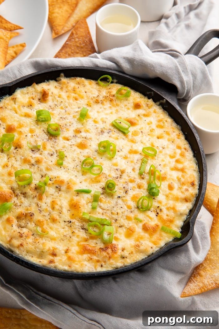 Deconstructed Crab Rangoon Dip 3 A skillet of golden-brown, bubbly crab rangoon dip, garnished with fresh green onions