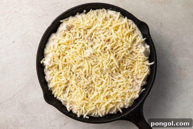 Baked crab rangoon dip in a skillet, topped with melted mozzarella