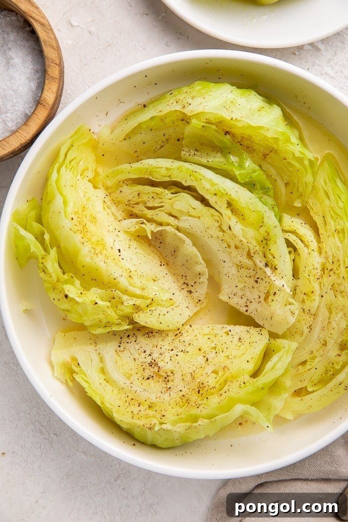 A close-up shot of boiled cabbage in a white bowl, showcasing its beautiful texture and the melting butter, ready to be enjoyed.