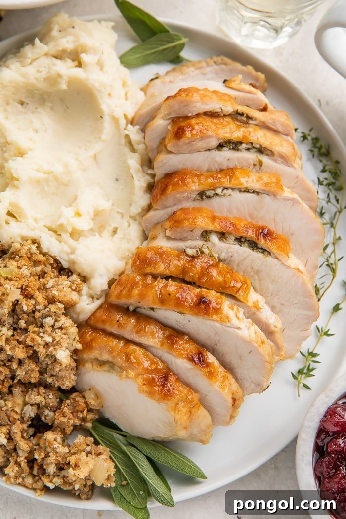 Delicious Instant Pot Turkey Breast 4 Instant Pot turkey breast slices served on a plate with classic Thanksgiving sides: creamy mashed potatoes and flavorful stuffing, all topped with homemade gravy.