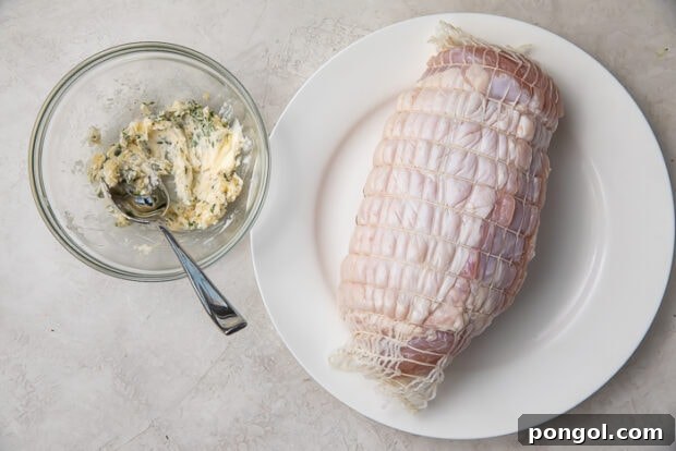 Applying garlic herb butter under turkey skin