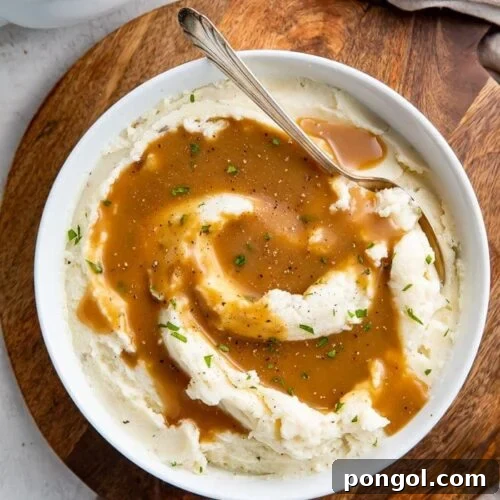 Close-up of a rich, creamy brown gravy in a white bowl, ready to be served.
