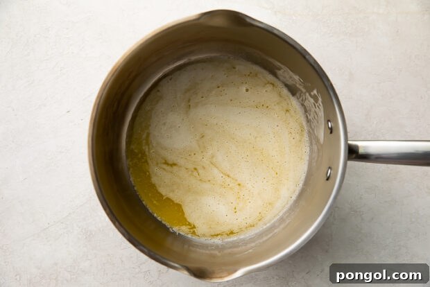 Step 1: Melting butter and whisking in flour to create a roux.