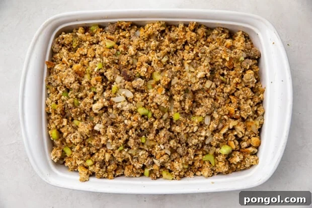 Heirloom Sausage Stuffing 10 Cooked sausage stuffing in a baking dish, with a serving spoon.