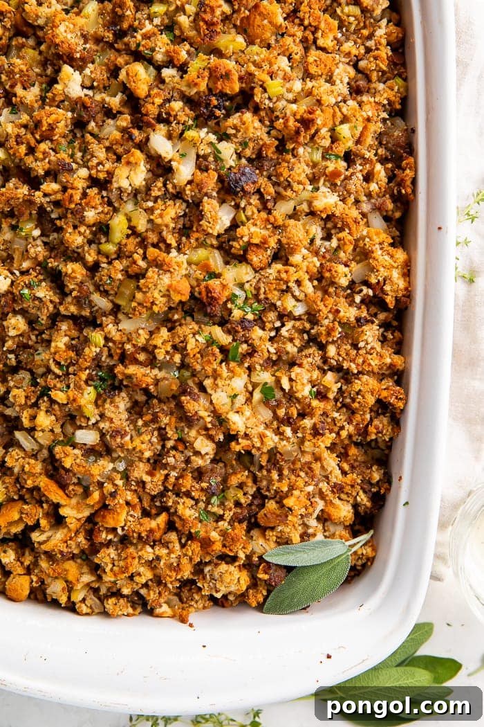 Heirloom Sausage Stuffing 4 Close-up overhead shot of golden-brown sausage stuffing in a white baking dish, showing rich texture and ingredients.