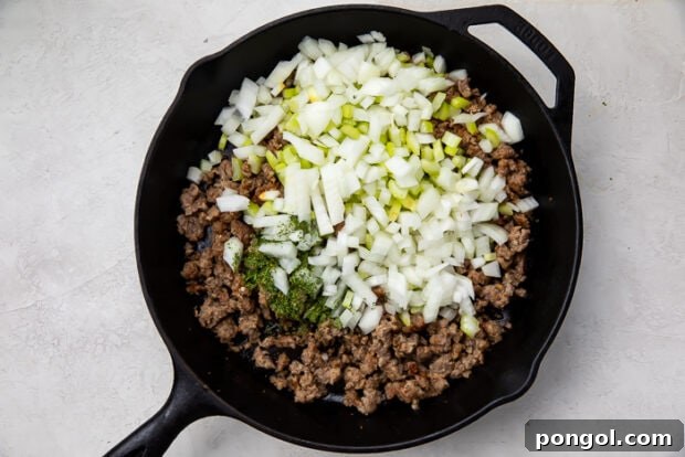 Heirloom Sausage Stuffing 8 Sausage, onions, parsley, and celery cooking together in a frying pan.