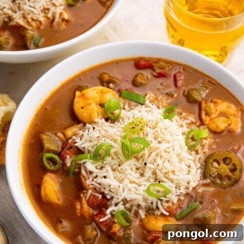 Two bowls of shrimp and andouille gumbo on a white background