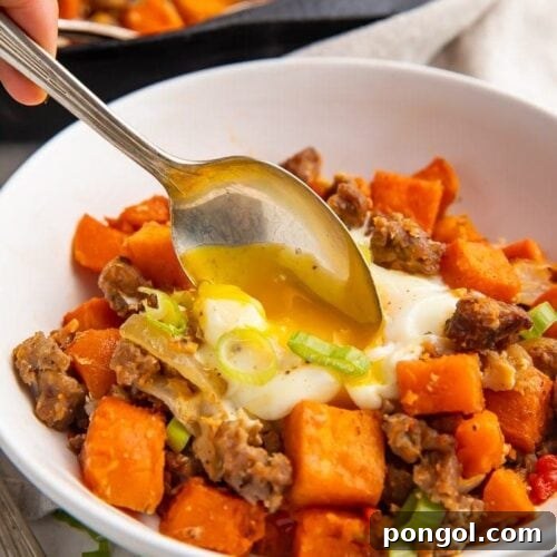 A spoon dipped into a white bowl of sweet potato hash