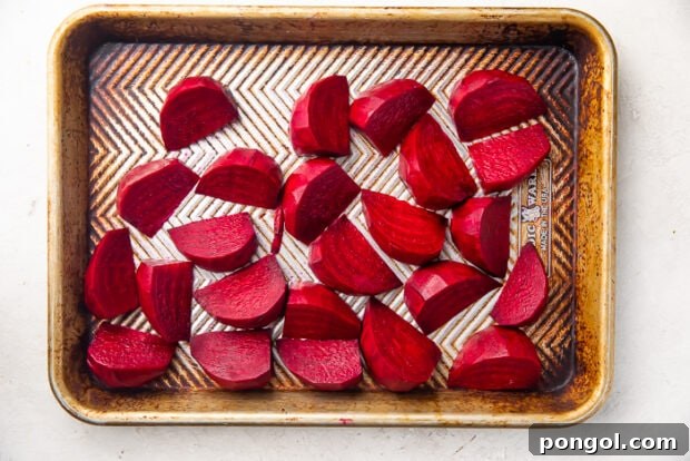 Dark reed beets cut into wedges and placed on silver sheet pan