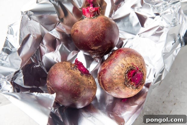 Whole beets with trimmed stem on sheet of aluminum foil