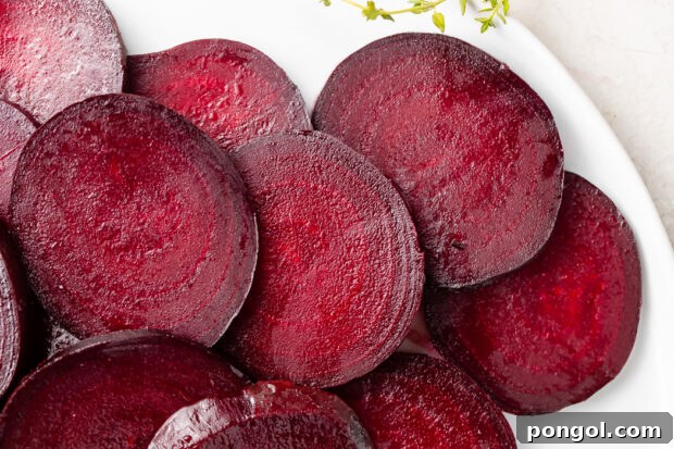 Dark red roasted beet medallions on white dish