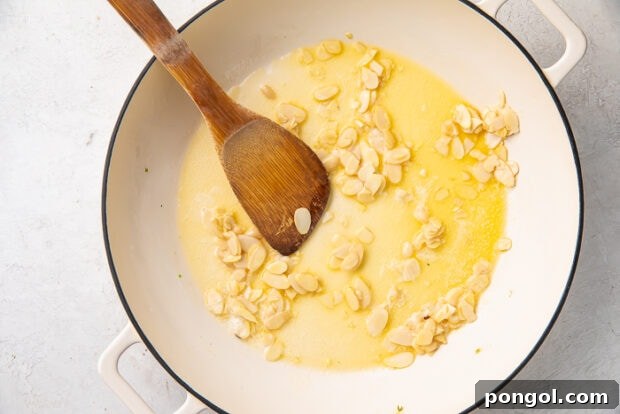 Slivered almonds toasting in butter in a skillet.