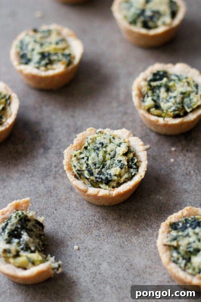 Several spinach and artichoke dip tarts