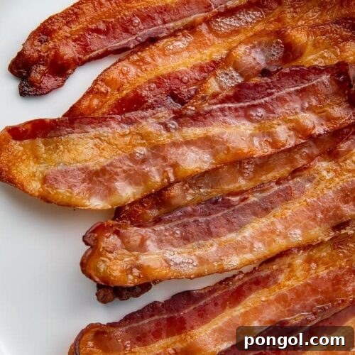 Oven-cooked bacon strips on a white plate