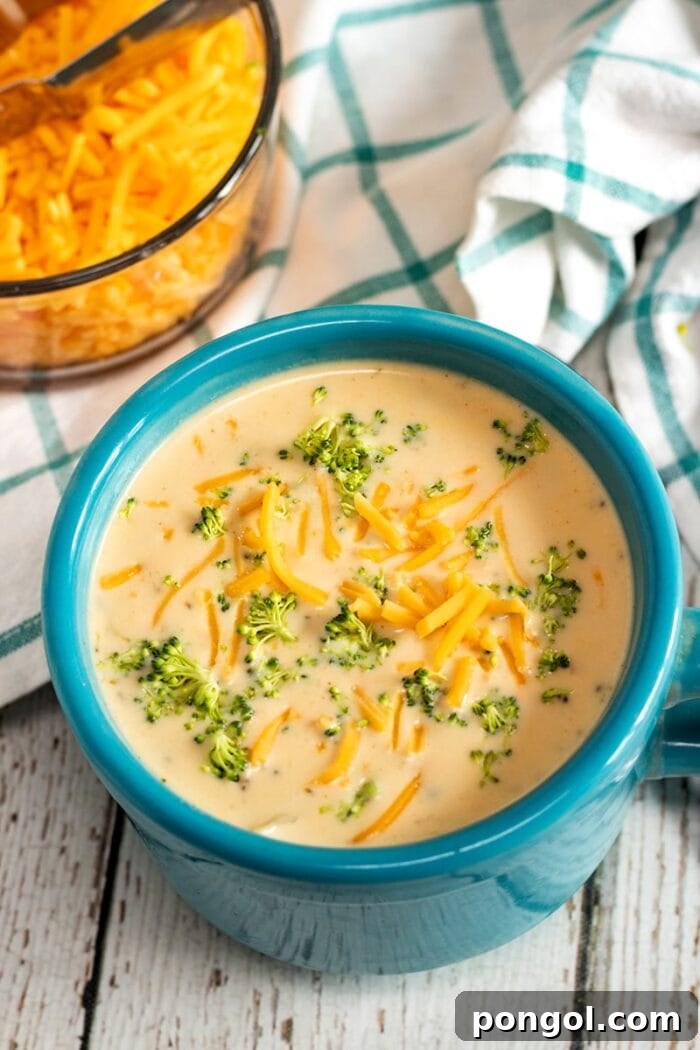 Blue bowl holding yellow creamy broccoli cheddar vegetarian Instant Pot soup